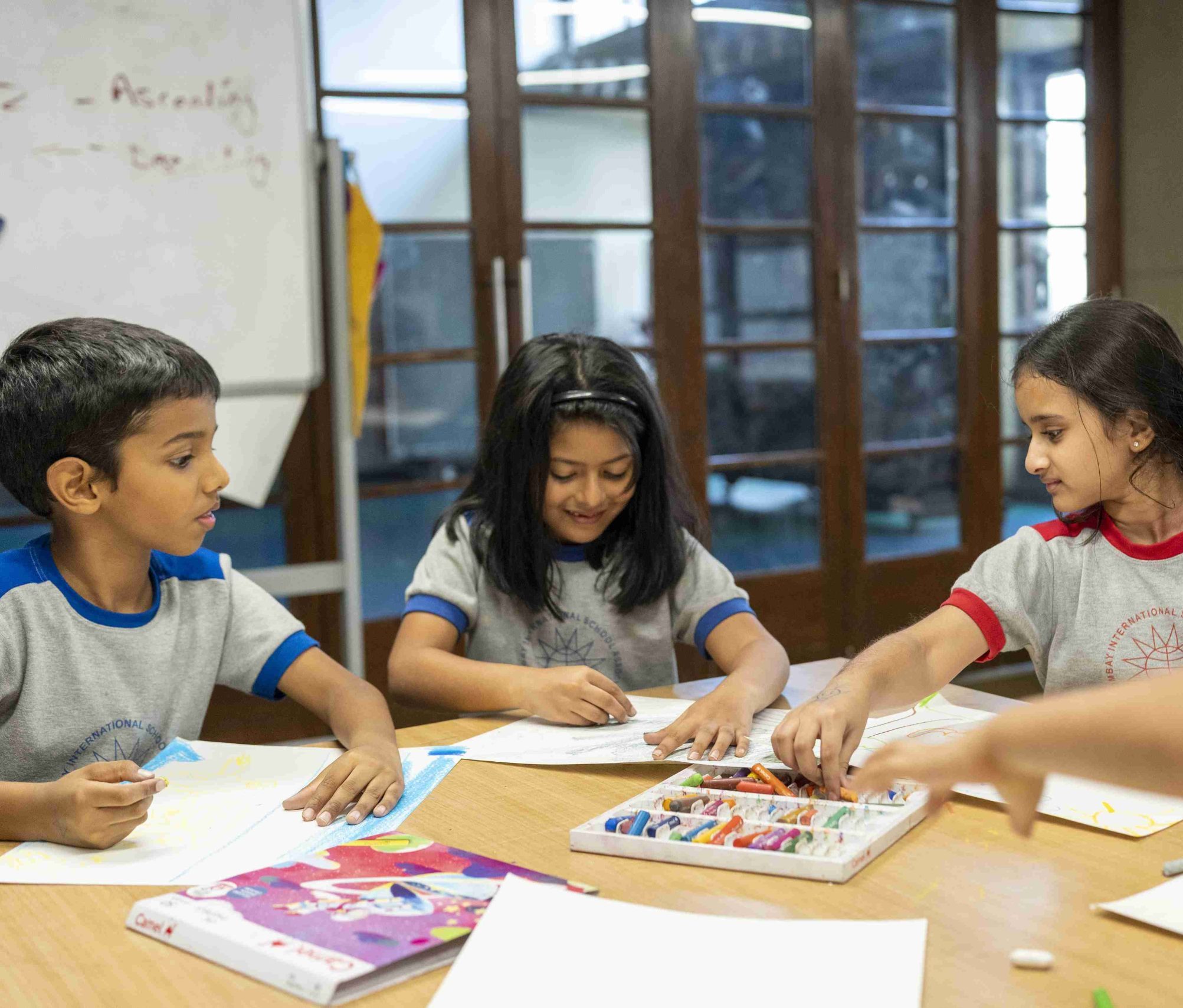 kids using crayons to paint their drawings