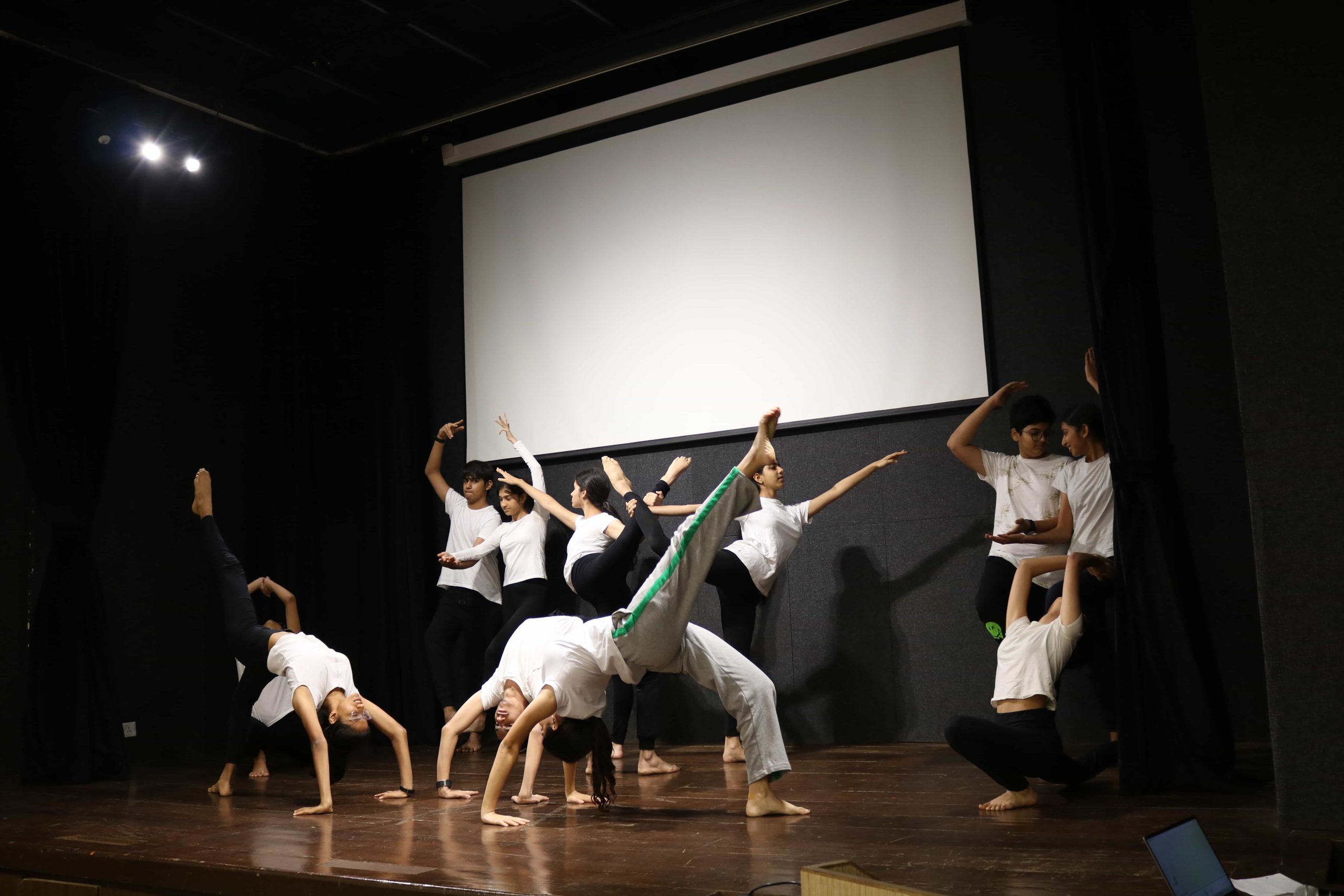 Students performing yoga on stage